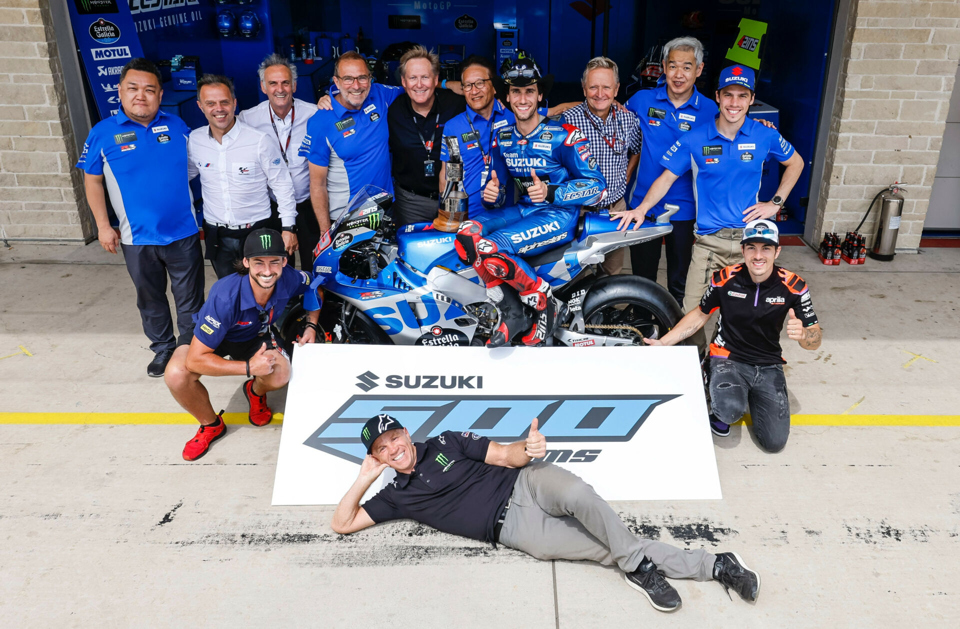 500 Grand Prix podiums for Suzuki! (Back row left to right) Ken Kawauchi, Loris Capirossi, Franco Uncini, Livio Suppo, Kerry Graeber – Vice President, Suzuki Motor USA, Masami Haga – President, Suzuki Motor USA, Alex Rins, Kevin Schwantz, Shinichi Sahara, Joan Mir, (kneeling from left) John Hopkins, Maverick Viñales, and (prone) Randy Mamola. Photo courtesy Suzuki Motor USA, LLC.