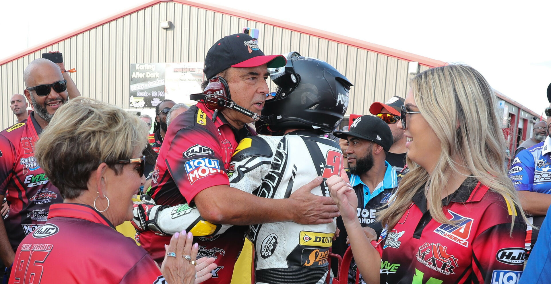 Frank Angel hugs rider Gus Rodio after Rodio finished second in MotoAmerica Junior Cup Race One at New Jersey Motorsports Park in 2021. Photo by Brian J. Nelson.
