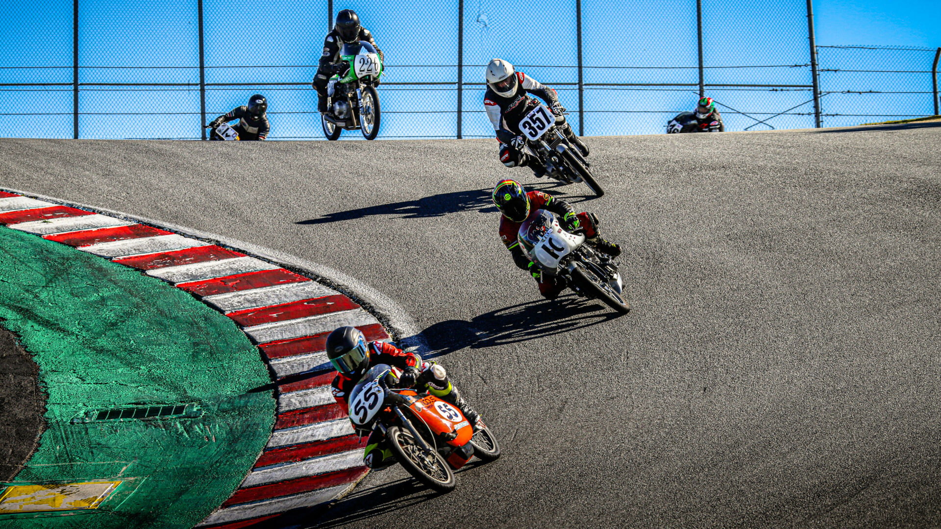 AHRMA 200 Grand Prix+ racers Jon Munns (55), Greg Glevicky (1C), Joe Koury (357) and Tim Manoney (226) navigate the famous Corkscrew during the 2021 AHRMA Classic MotoFest of Monterey at Laguna Seca. Photo by etechphoto.com, courtesy AHRMA.