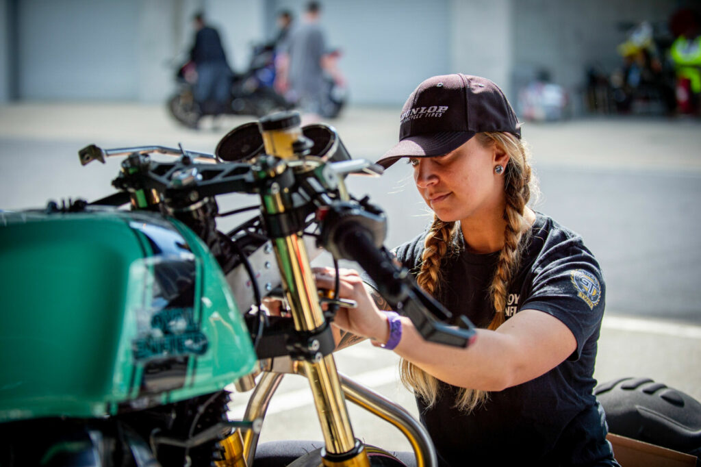 The BTR women do their own wrenching in the paddock, as Kayleigh Buyck demonstrates. Photo by Jen Muecke, courtesy Royal Enfield.