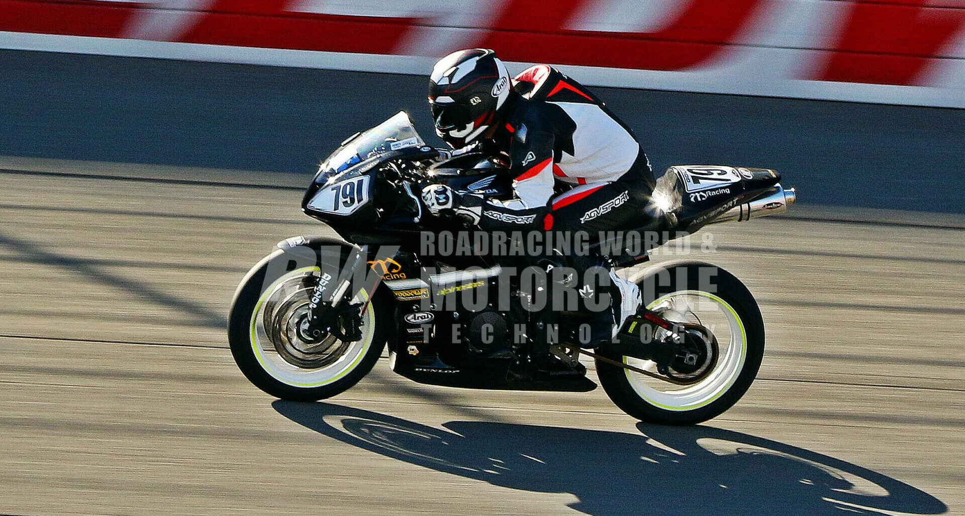 Before crash-testing safety gear and smashing race bodywork: The author and his Honda CBR600RR on the banking at Auto Club Speedway, wearing an Arai Regent-X helmet, AGV Monza one-piece racing suit and gloves, Alpinestars Supertech R boots and body armor. All performed without fail. Photo courtesy Caliphotography.com.