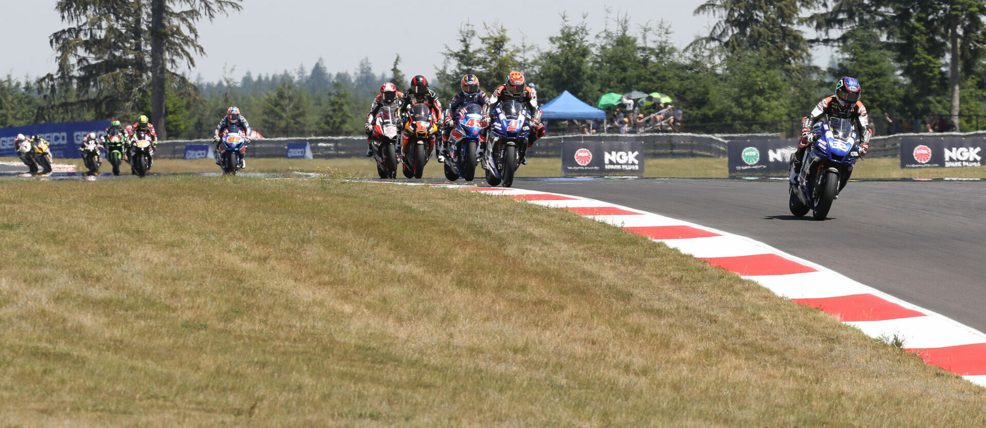 Jake Gagne (32) leads Josh Herrin (2), Cameron Petersen (32), Mathew Scholtz (11), Loris Baz (76), Bobby Fong (50), and the rest of the field early in Superbike Race Two at Ridge Motorsports Park in 2021. Photo by Brian J. Nelson.