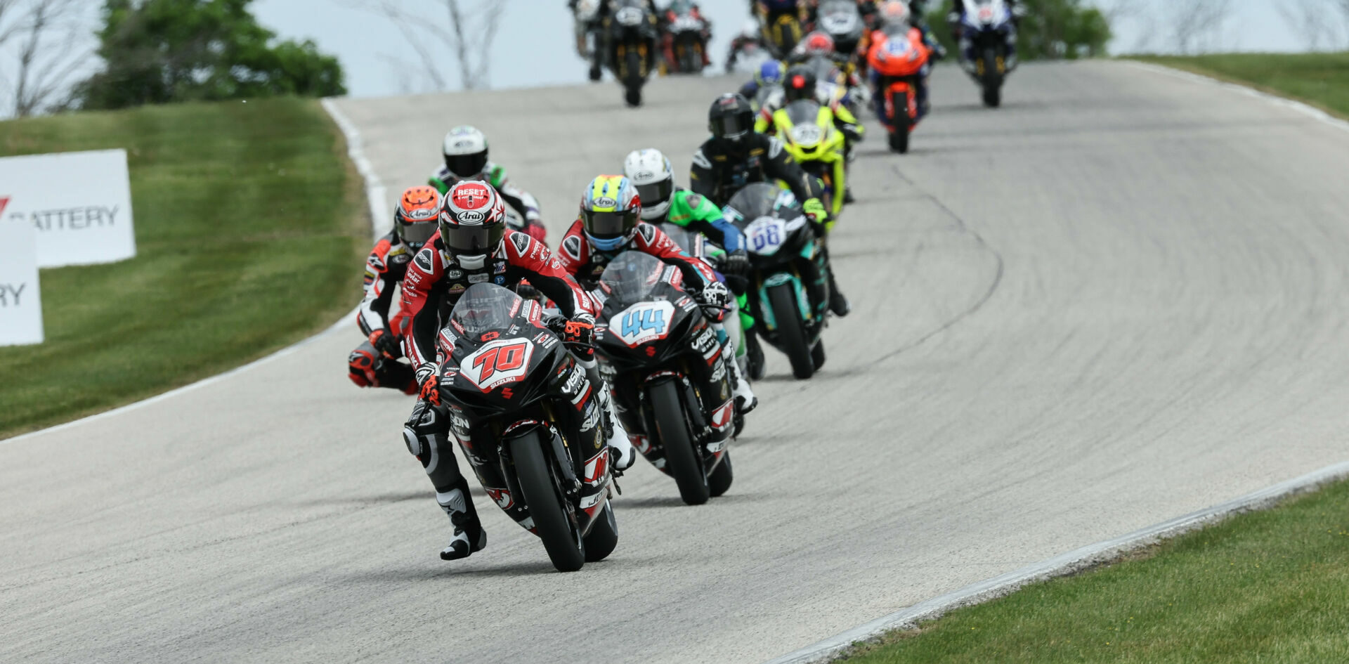 MotoAmerica Supersport races can still be viewed on the MAVTV cable network and also via digital streaming on the FloRacing app. Here, Tyler Scott (70) leads Sam Lochoff (44), Josh Herrin (hidden behind Scott), and the rest of the field in Supersport Race One at Road America. Photo by Brian J. Nelson.