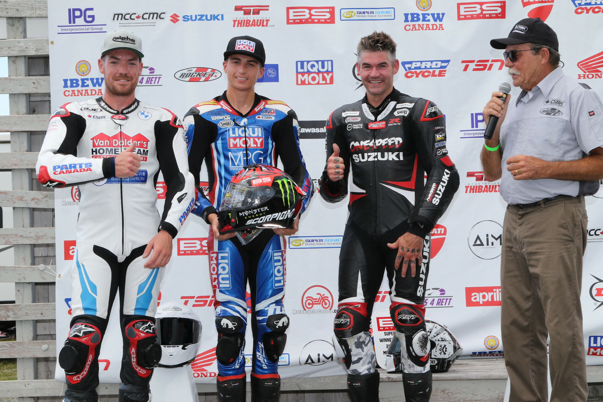 Canadian Superbike racers (from left) Ben Young, Alex Dumas, and Trevor Daley join series announcer Frank Wood in announcing the Canadian Rider Fund raffle of a Fabio Quartararo-autographed Scorpion race helmet, at Atlantic Motorsport Park. Photo by Rob O'Brien, courtesy CSBK/PMP.
