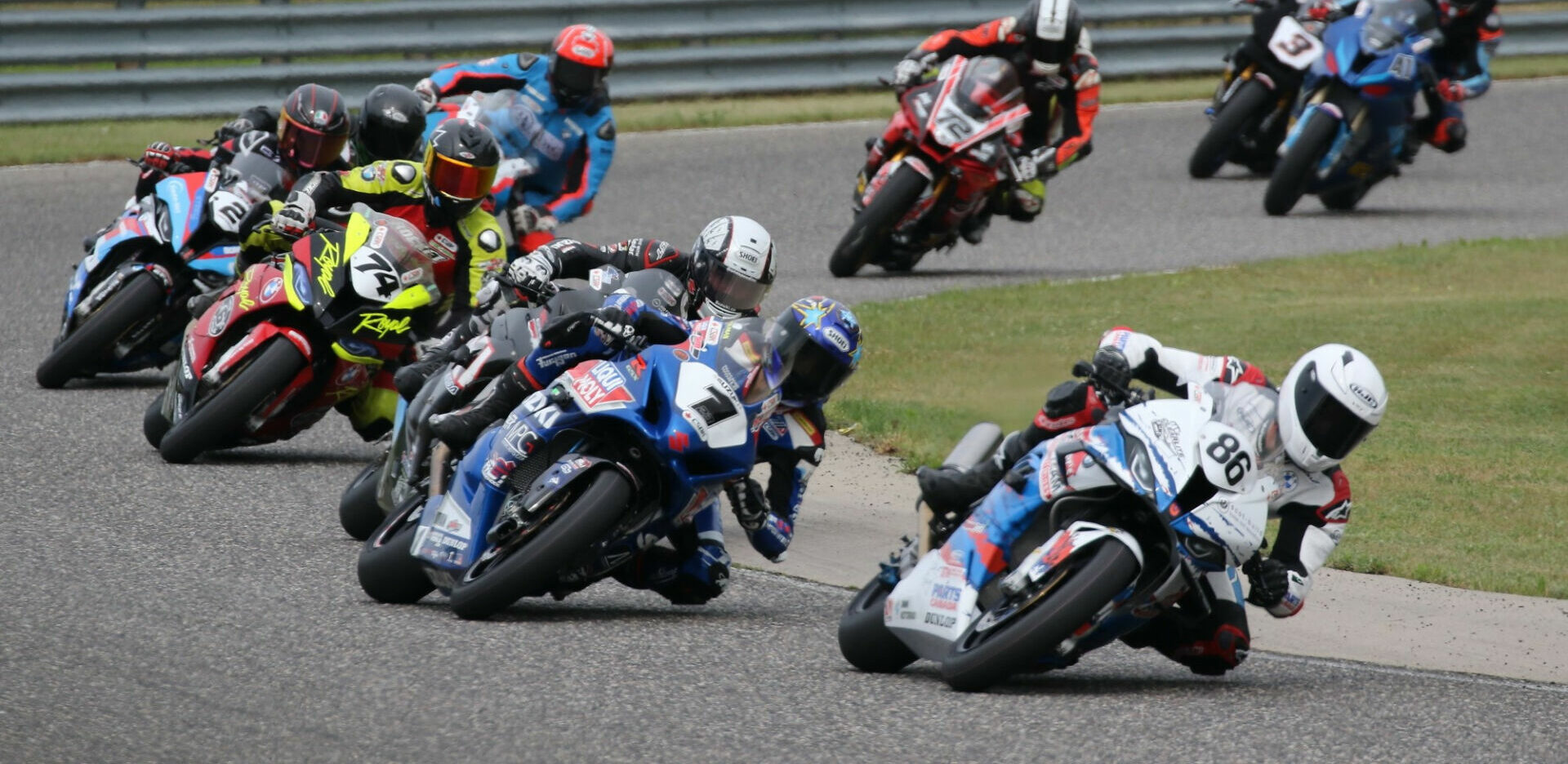 Ben Young (86) leads the opening lap of Pro Superbike Race Two at Calabogie Motorsports Park over eventual race winner Alex Dumas (1) and the rest of the field. Young would go on to finish second ahead of Trevor Daley (hidden) in third. Photo by Rob O'Brien, courtesy CSBK/PMP.