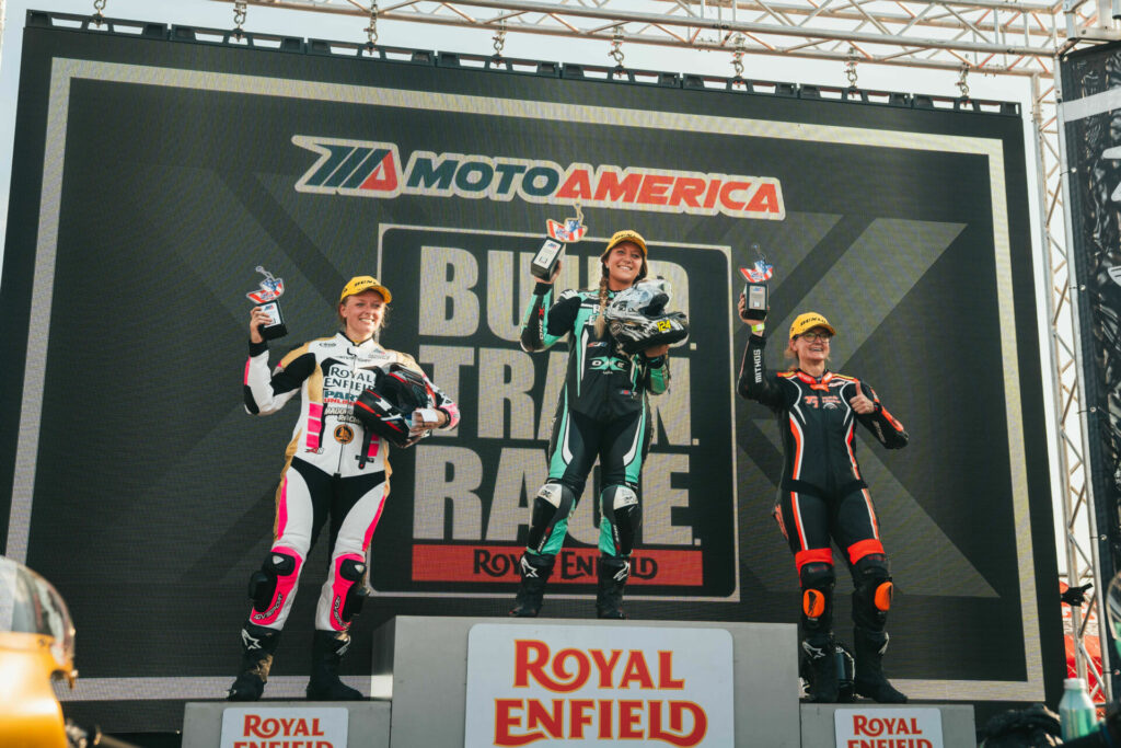 MotoAmerica Royal Enfield Build. Train. Race. (BTR) race winner Kayleigh Buyck (center), runner-up Chloe Peterson (left), and third-place finisher Jenny Chancellor (19) on the podium at Brainerd International Raceway. Photo courtesy Royal Enfield North America.
