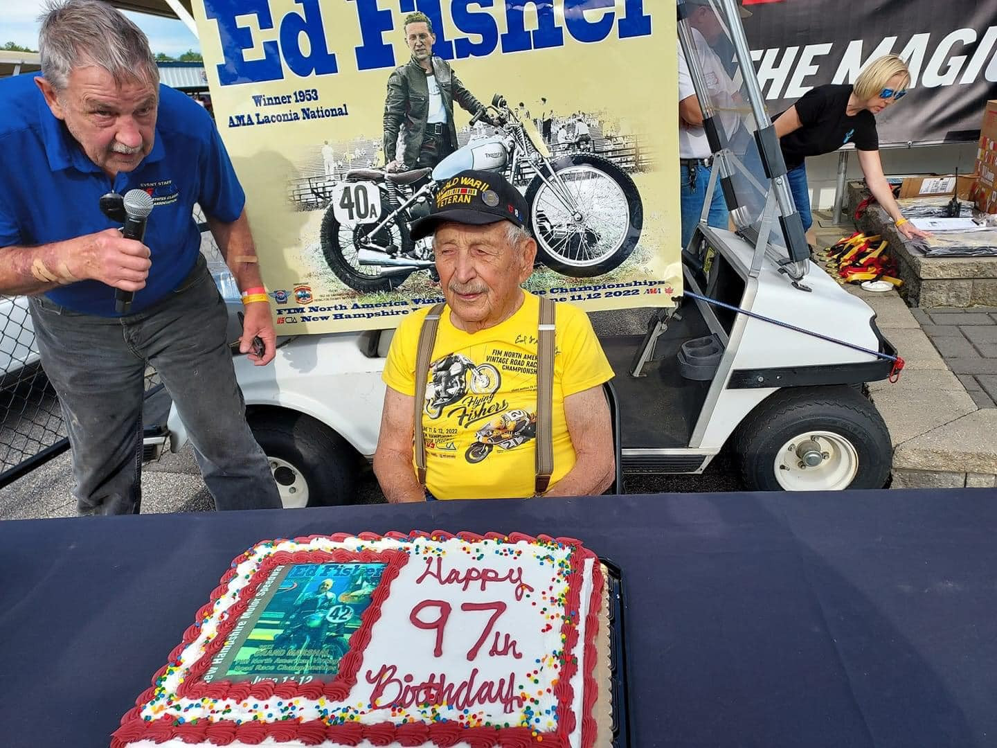 Ed Fisher (R.I.P.) celebrated his 97th birthday as Co-Grand Marshal of the USCRA/FIM North America Vintage Road Racing Championship event June 11, 2022 at New Hampshire Motor Speedway. Former racer and event announcer Richard Chambers looks to interview Fisher. Photo courtesy Kimberly Rivers.