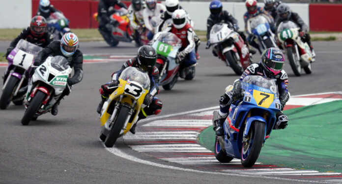 Reigning British Superbike Champion Tarran "Taz" Mackenzie (7), on Jean-Philipe Ruggia's 1991 Yamaha YZR500, and his father Niall Mackenzie (3), on Gene Romero's Daytona 200-winning 1975 Yamaha TZ750, lead exhibition laps of classic racebikes at Donington Park. Photo courtesy Yamaha Racing Heritage Club.