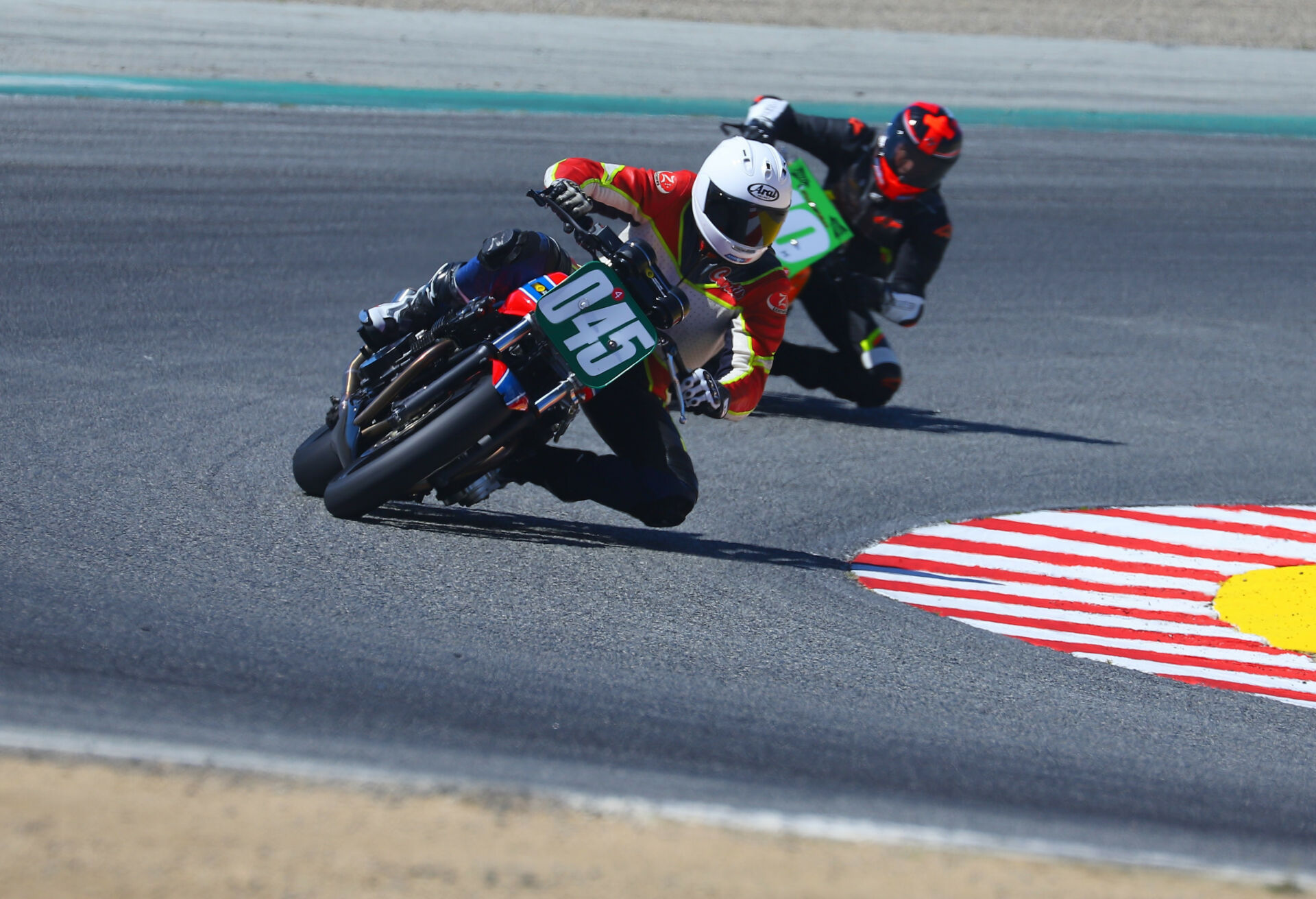 Curtis Adams (045) leads Mark Miller during an AHRMA Vintage Cup race at Laguna Seca. Photo by etechphoto.com, courtesy AHRMA.