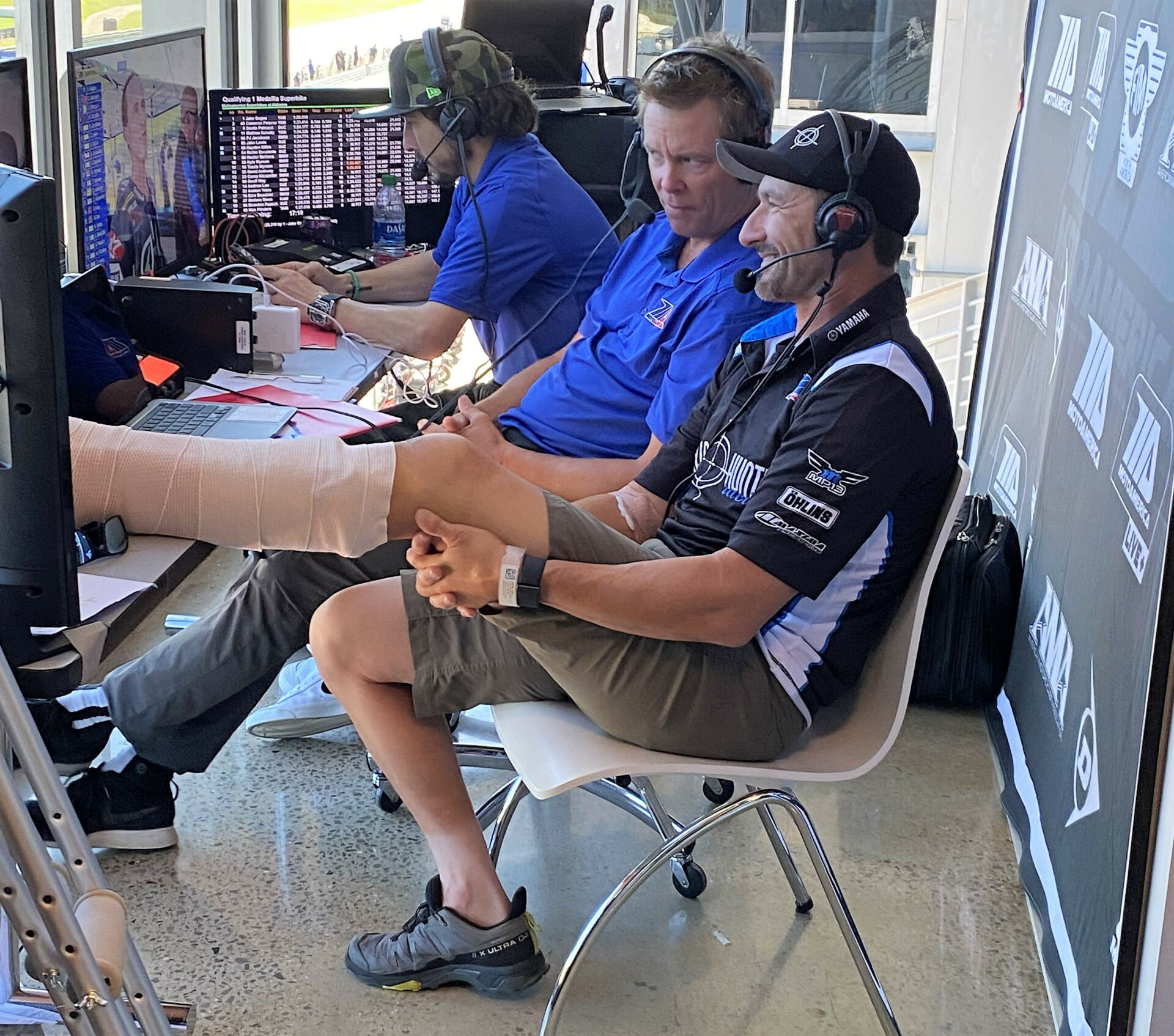 Josh Hayes (right), with his broken left leg elevated, joins Robbie Floyd (center), and Roger Hayden (left) in the MotoAmerica Live+ announcing booth at Barber Motorsports Park. Photo by David Swarts.