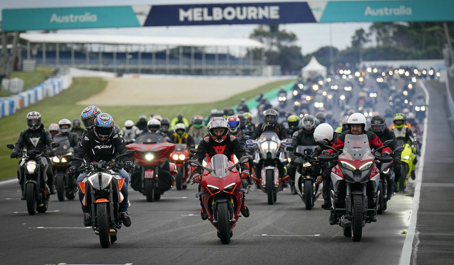 Remy Gardner (on orange KTM) and Jack Miller (on red Ducati) lead a parade of motorcyclists around the Phillip Island Grand Prix Circuit. Photo courtesy Dorna.