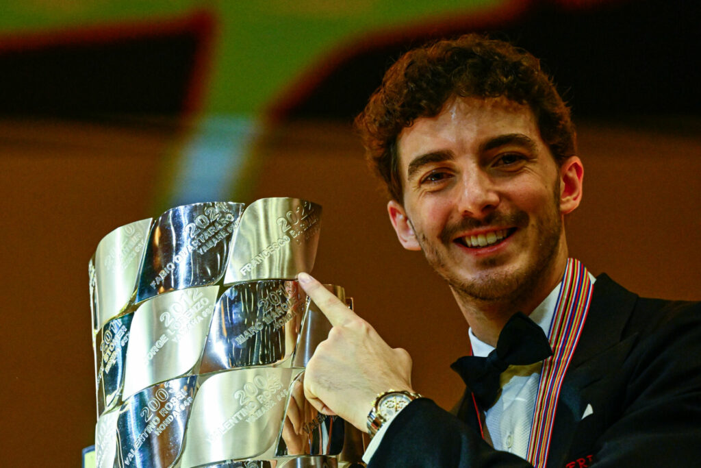 2022 MotoGP World Champion Francesco Bagnaia pointing to his name on the MotoGP World Championship trophy. Photo courtesy Dorna.