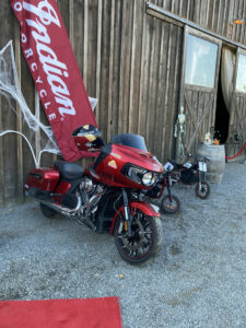 Tyler O'Hara's Indian streetbike and a pair of electric Indian minibikes for his kids, parked in front of the event venue.