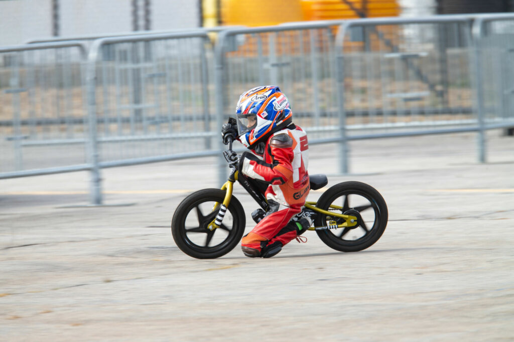 A young rider dragging their knee while riding a StaCyc electric balance bike. Photo by Sam Draiss, courtesy NEMRR.
