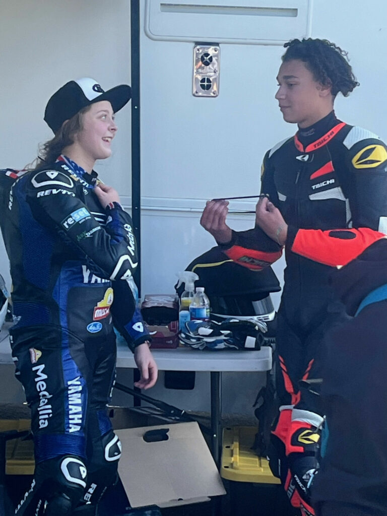 Kayla Yaakov (left) and her MP13 Racing Yamaha teammate Aiden Sneed (right) talk in the pits after finished 0.047 second apart in CRA's 400 GT Expert race February 11 at Buttonwillow Raceway Park. Sneed and Yaakov both rode Yamaha YZF-R3 motorcycles. According to Team Owner Melissa Paris, Sneed's bike had an engine with a 2mm overbore kit, and Yaakov's bike was fitted with the GYTR engine race kit - both of which are MotoAmerica Junior Cup-legal. Sneed took the victory. Photo by Ron Melton.  