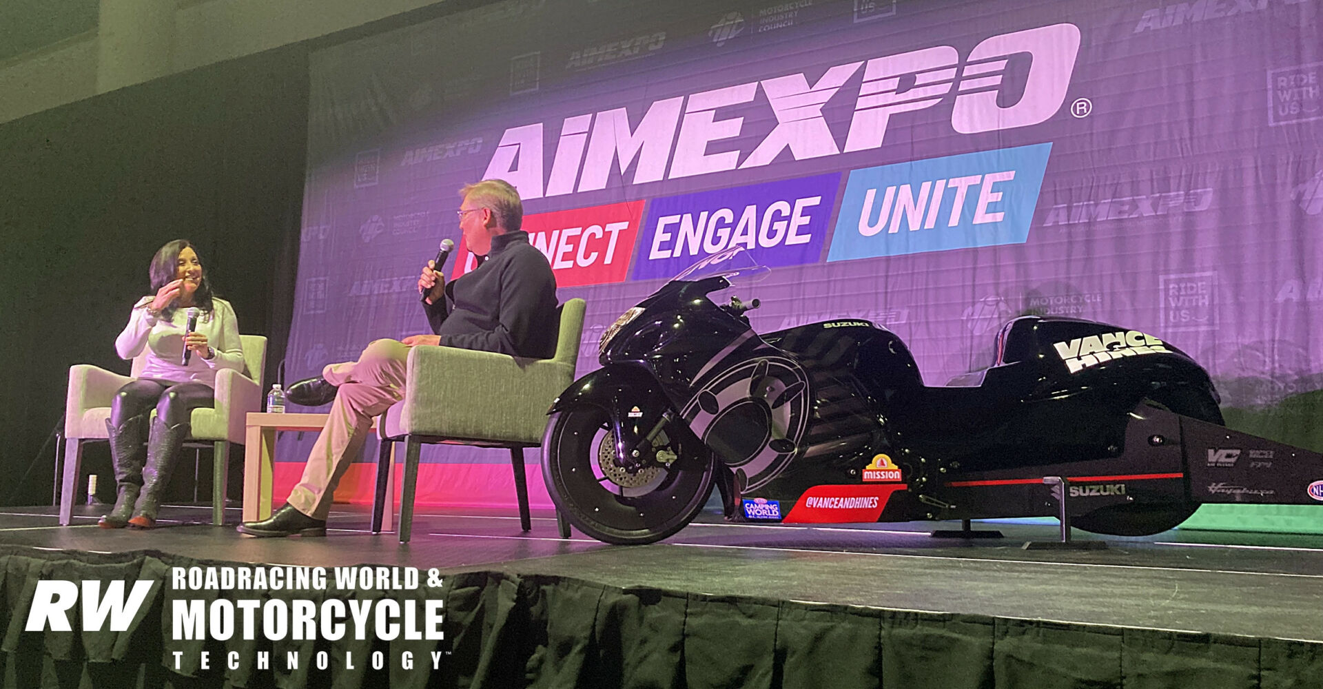 Angelle Sampey discusses her Pro Stock drag racing career with Suzuki's Kerry Graeber at the AIM Expo in Las Vegas. Photo by Michael Gougis.