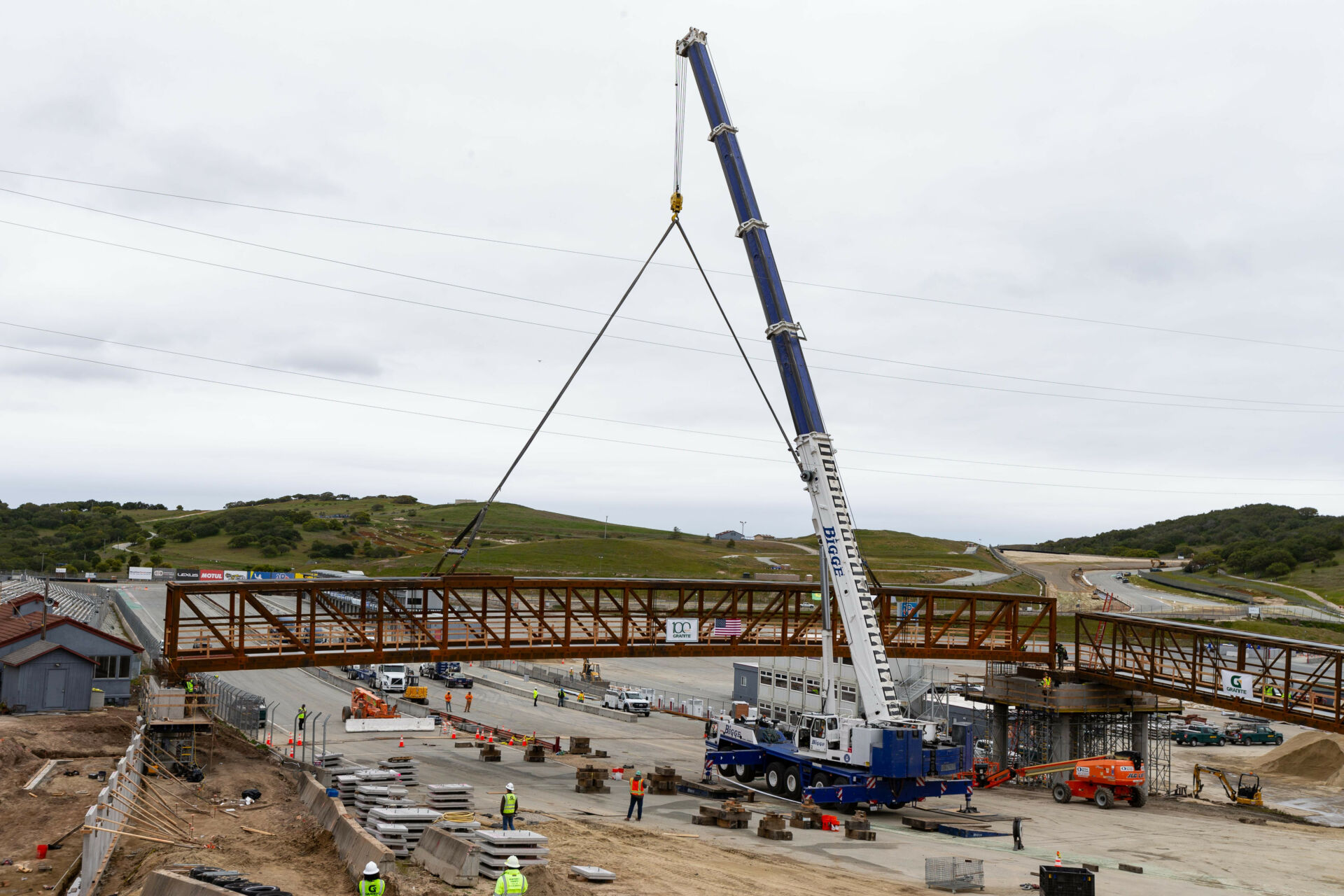 The 160-foot, 71-ton main section of the new Start/Finish bridge is lifted into place at WeatherTech Raceway Laguna Seca. Photo by TM Hill Photographer.