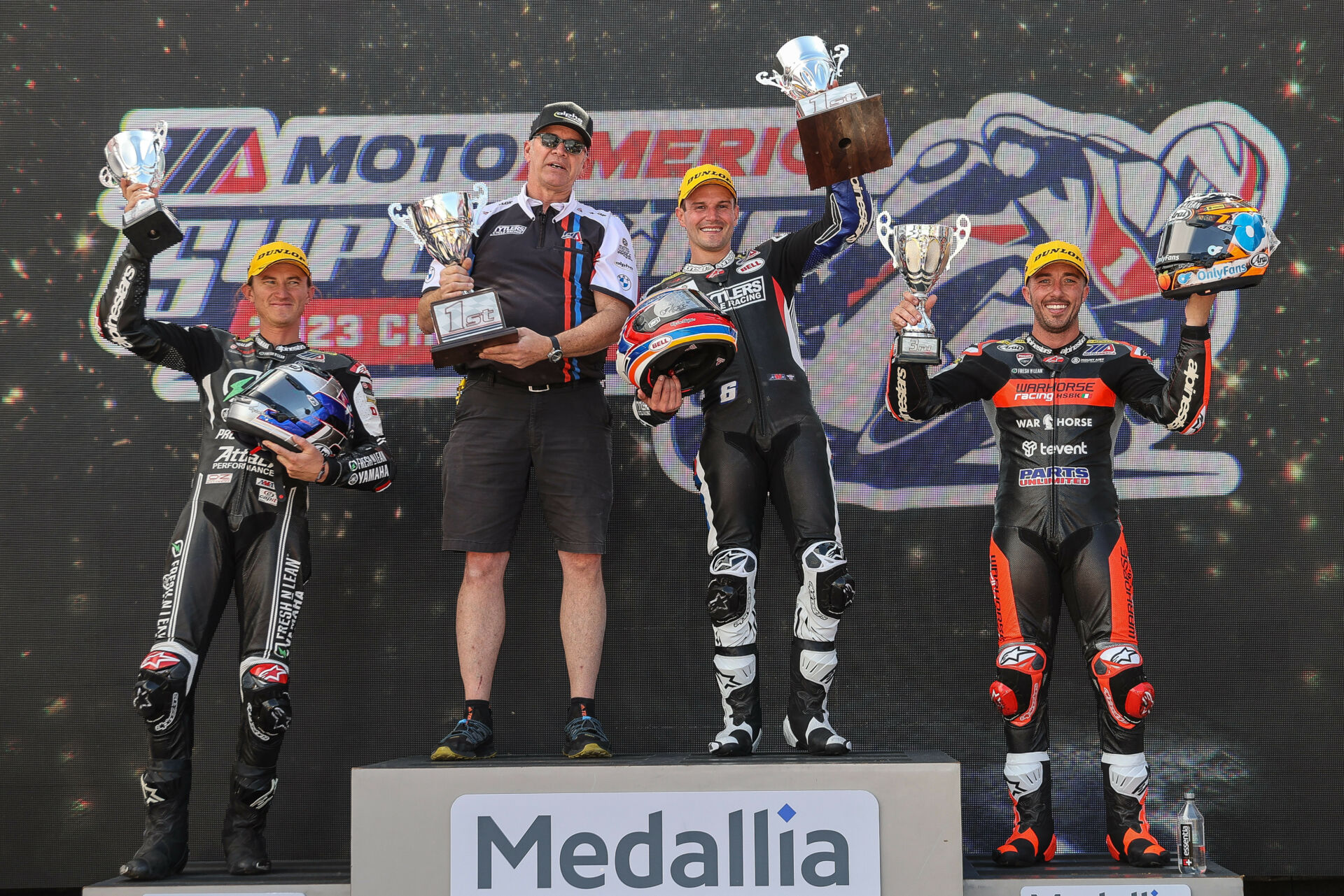 Medallia is continuing its title sponsorship of the 2023 MotoAmerica Medallia Superbike Championship. Here, Road Atlanta Race One winner shares the podium with his Crew Chief Dave Weaver, runner-up Jake Gagne (left) and third-place finisher Josh Herrin (right). Photo by Brian J. Nelson.