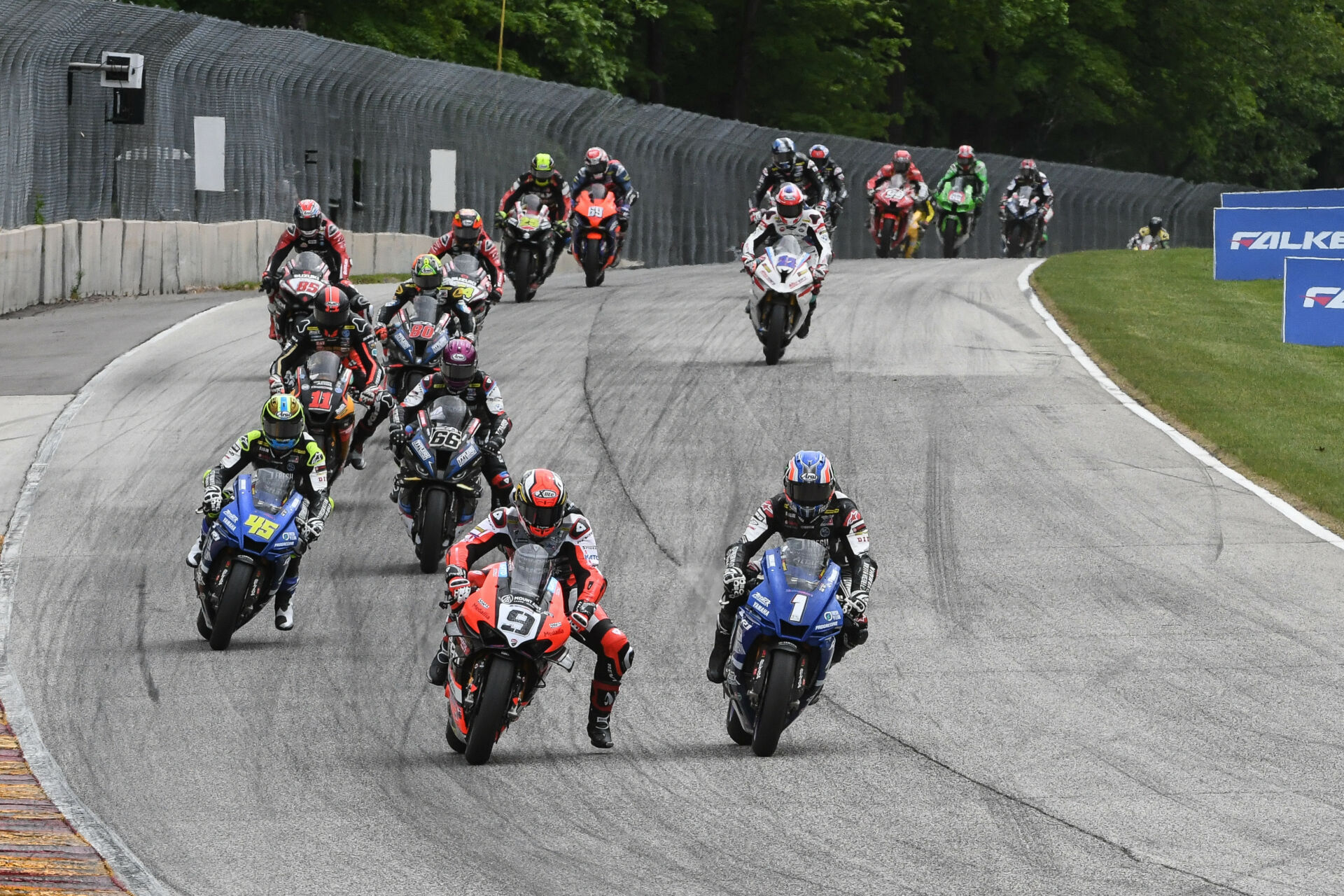 The start of MotoAmerica Superbike Race One at Road America in 2022 with Danilo Petrucci (9) and Jake Gagne (1) fighting for the lead into Turn Five. Photo by Brian J. Nelson.