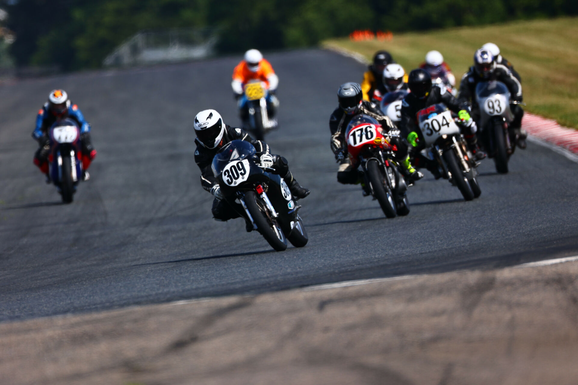 Tim Joyce (309) leads Tony Read (176), Kevin Dinsmoor (304), Daniel May (93), Dan Sokolich (77Z), and the rest during an AHRMA Vintage Cup race at NJMP. Photo by etechphoto.com, courtesy AHRMA.