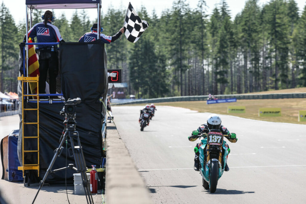 Stefano Mesa (137) takes the checkered flag on his Energica Eva Ribelle RS electric racebike. Photo by Brian J. Nelson, courtesy Energica.