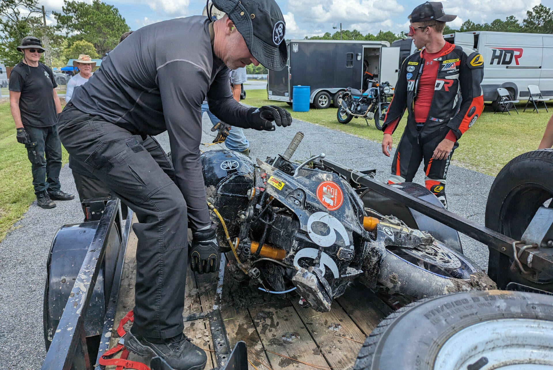 Army of Darkness Captain Sam Fleming pulls his crashed Yamaha YZF-R1 off the crash truck's trailer the day before the N2/WERA National Endurance four-hour race at Roebling Road Raceway. Team rider Hunter Dunhaam (right) and Crew Chief Tim Gooding (far left) stand by to help. Photo courtesy Army of Darkness.