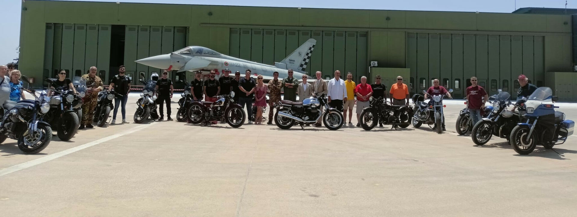 Motorcycle and aviation enthusiasts gather with a Eurofighter Typhoon of the Italian Air Force's 37th Stormo and Elena Bagnasco (center), President of the Giorgio Parodi Association and granddaughter of Moto Guzzi Co-Founder Giorgio Parodi. Photo courtesy Giorgio Parodi Association.