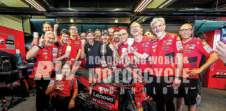 Francesco Bagnaia and mentor Valentino Rossi (in black) celebrate a Jerez win with the Ducati crew. Team Manager Davide Tardozzi is at far left and Ducati Corsa General Manager Gigi Dall'Igna is second from right.