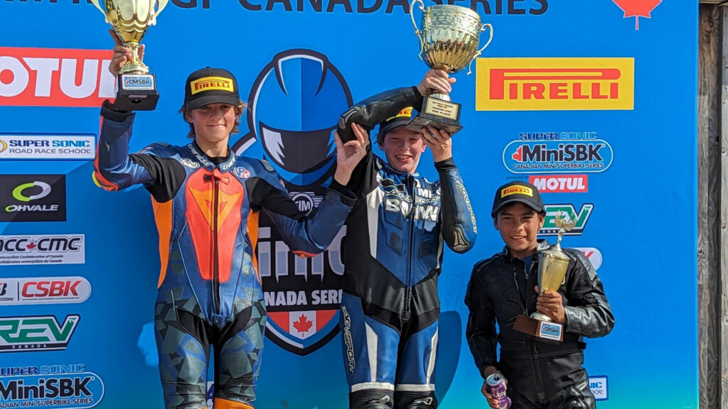 Ashton Parker (center) standing on top of the FIM MiniGP Canada podium with runner-up Ben Hardwick (left) and third-place finisher Michael Galvis (right). Galvis won the inaugural 2023 FIM MiniGP Canada Championship. Photo by Collin Fraser.