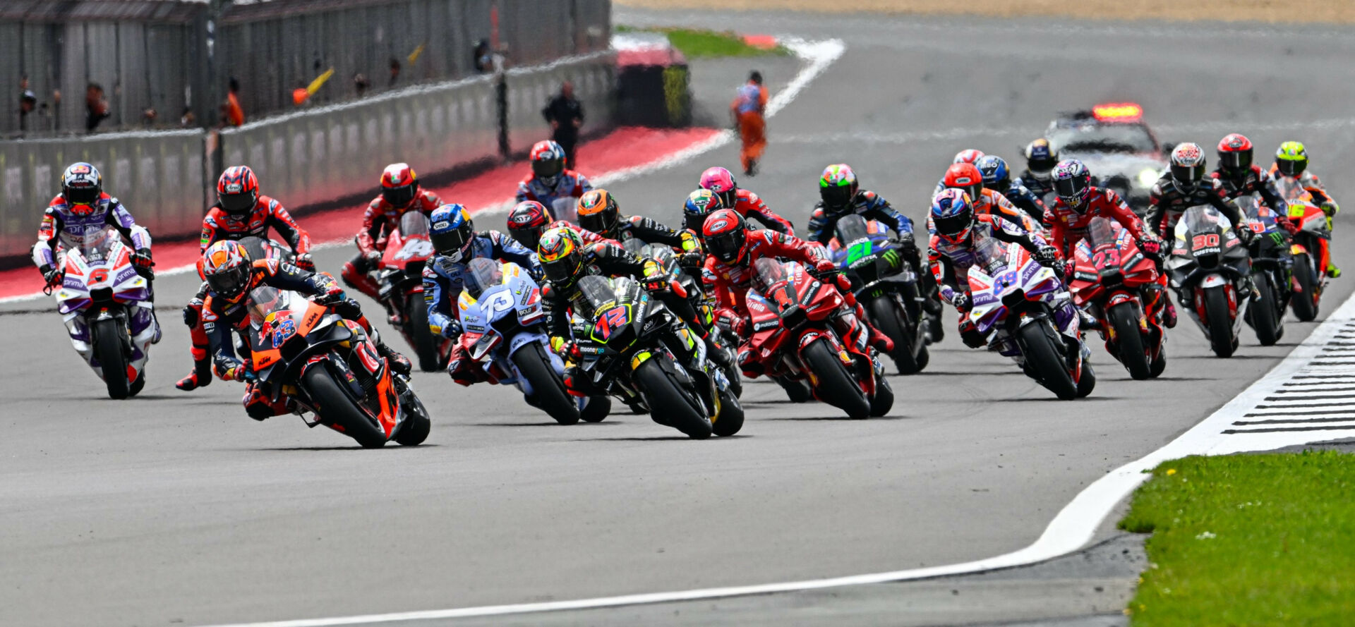 The start of the MotoGP race at Silverstone with Marco Bezzecchi (72) and Jack Miller (43) contesting the lead. Photo courtesy Dorna.