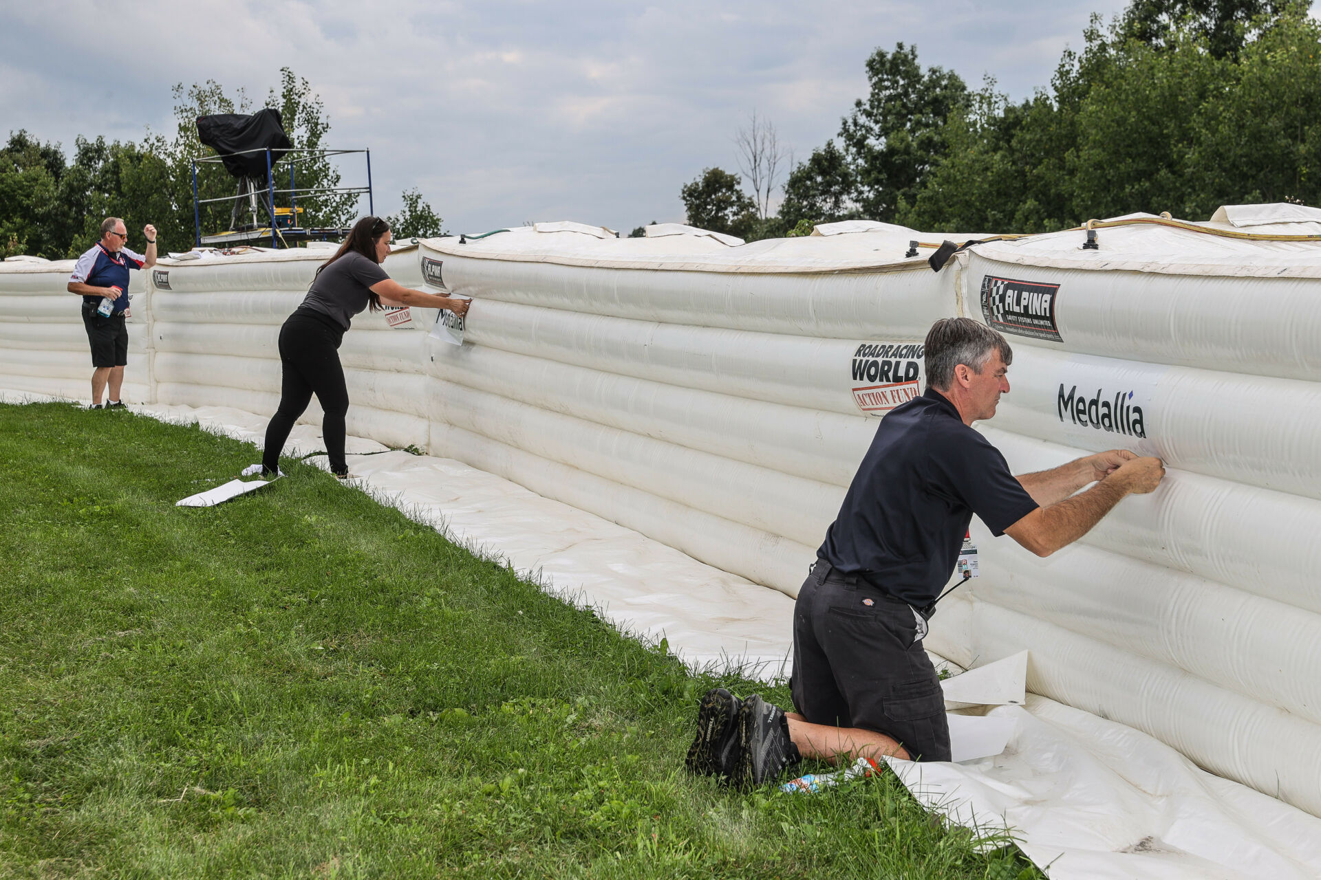 MotoAmerica Race Director Rick Hobbs (left) and Director of Operations Niccole Cox (center) also pitched in and helped FIMNA Safety Officer Dan Argano (right). Photo by Brian J. Nelson.