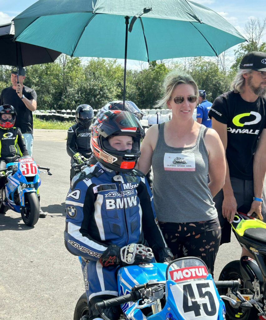 Riding instructor and former Pro racer Misti Hurst holding an umbrella over her 14-year-old son Ashton Parker prior to a race. Photo courtesy Misti Hurst.