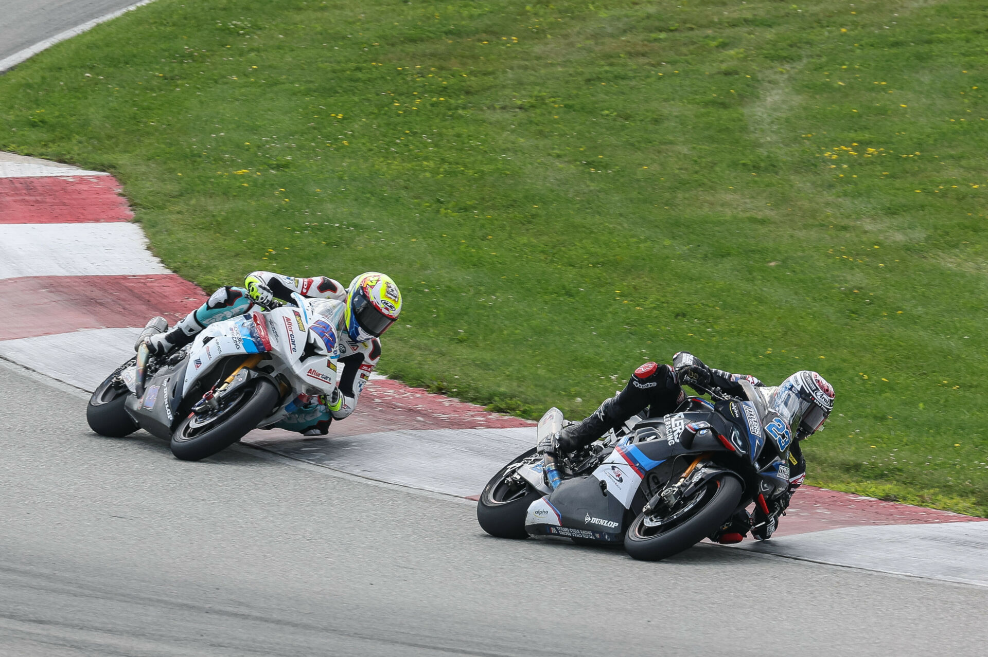 BMW racers Corey Alexander (23) and Ashton Yates (22) at speed at PittRace. Photo by Brian J. Nelson, courtesy BMW Motorrad Motorsport.