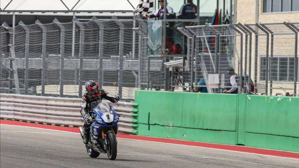 Jake Gagne (1) crosses the finish line and celebrates the 39th Superbike victory of his career. Photo by Brian J. Nelson.