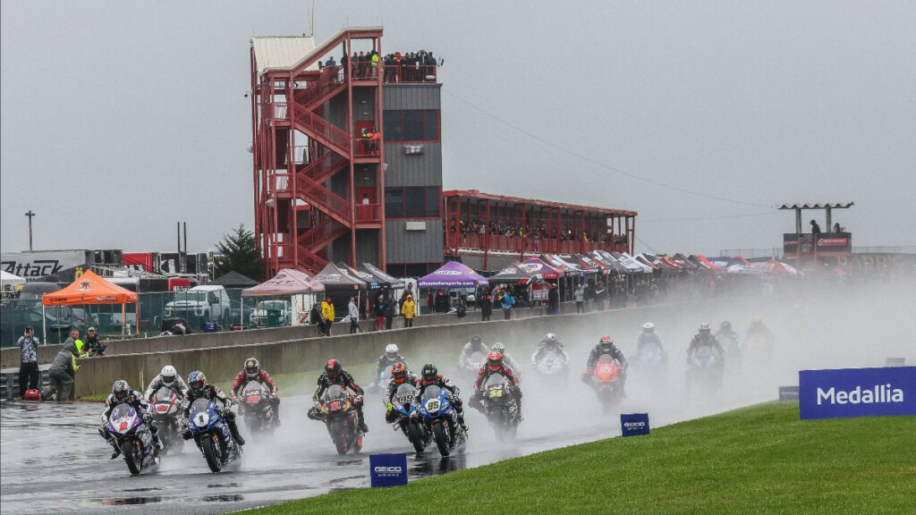 Jake Gagne (1), Josh Herrin (2), Mathew Scholtz (11), JD Beach (95) and the rest of the Medallia Superbike pack heads into a very wet turn one at New Jersey Motorsports Park on Saturday. Photo by Brian J. Nelson.