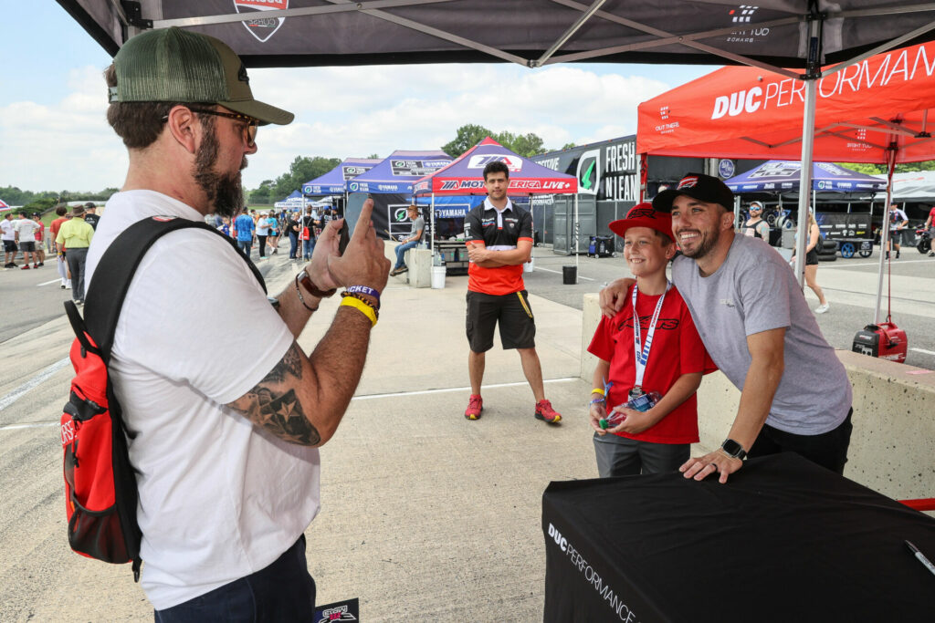 A young fan taking a photo with Superbike racer Josh Herrin earlier this season. Photo by Brian J. Nelson.