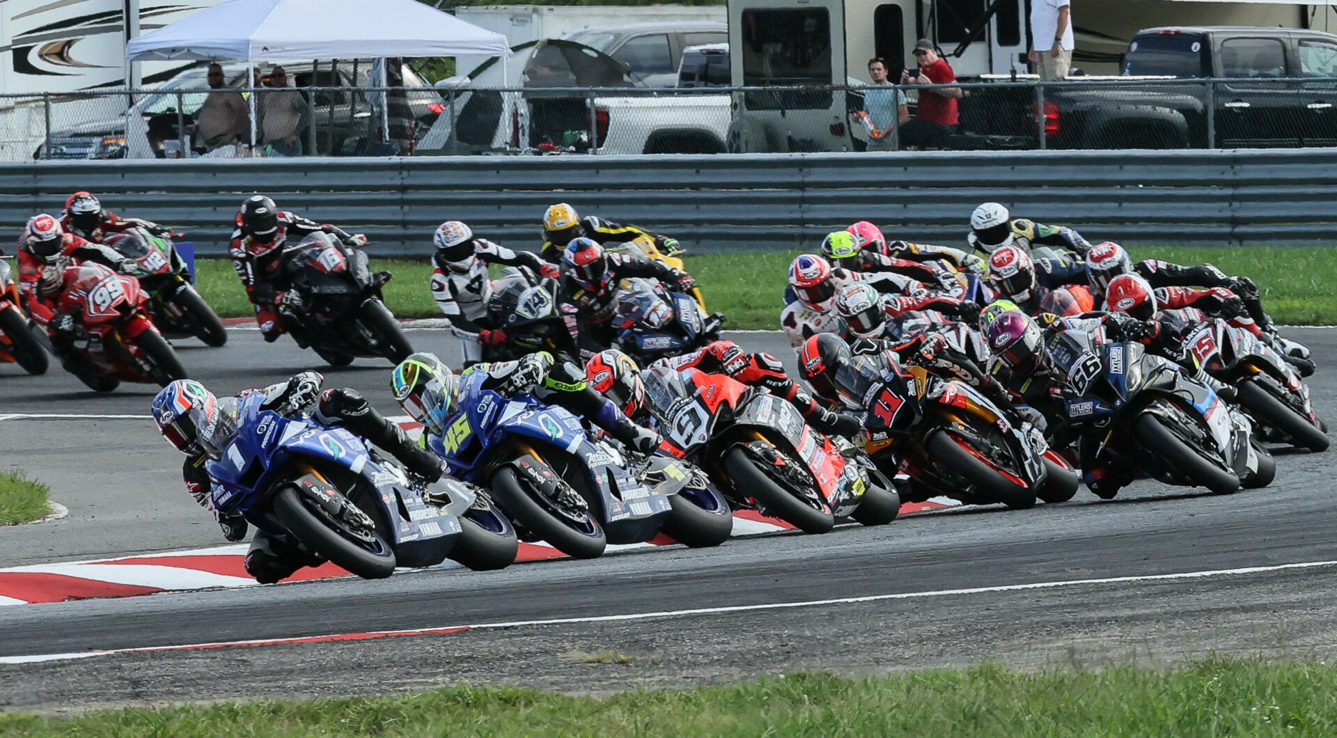 Jake Gagne (1) leads Cameron Petersen (45), Danilo Petrucci (9), Mathew Scholtz (11), PJ Jacobsen (66), and the rest of the field at the start of a MotoAmerica Superbike race in 2022 at NJMP. Photo by Brian J. Nelson.