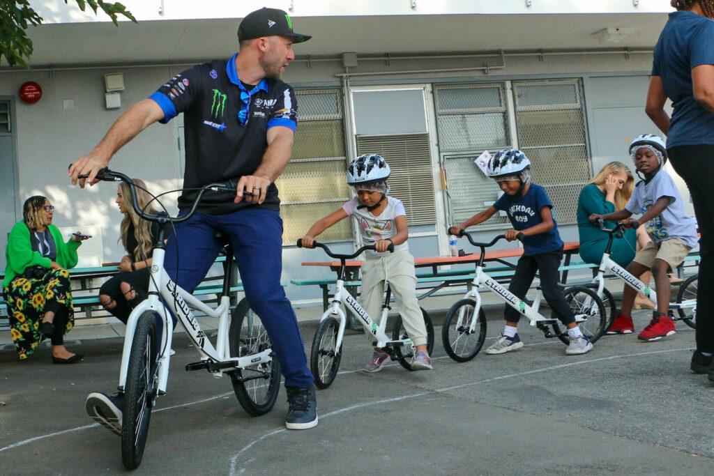 Yamaha Star Racing’s Supercross star Eli Tomac (left) helped deliver an All Kids Bike PE education package to kids at the 74th Street Elementary School in the Los Angeles Unified School District (LAUSD). Photo courtesy Yamaha Motor Corp., USA.