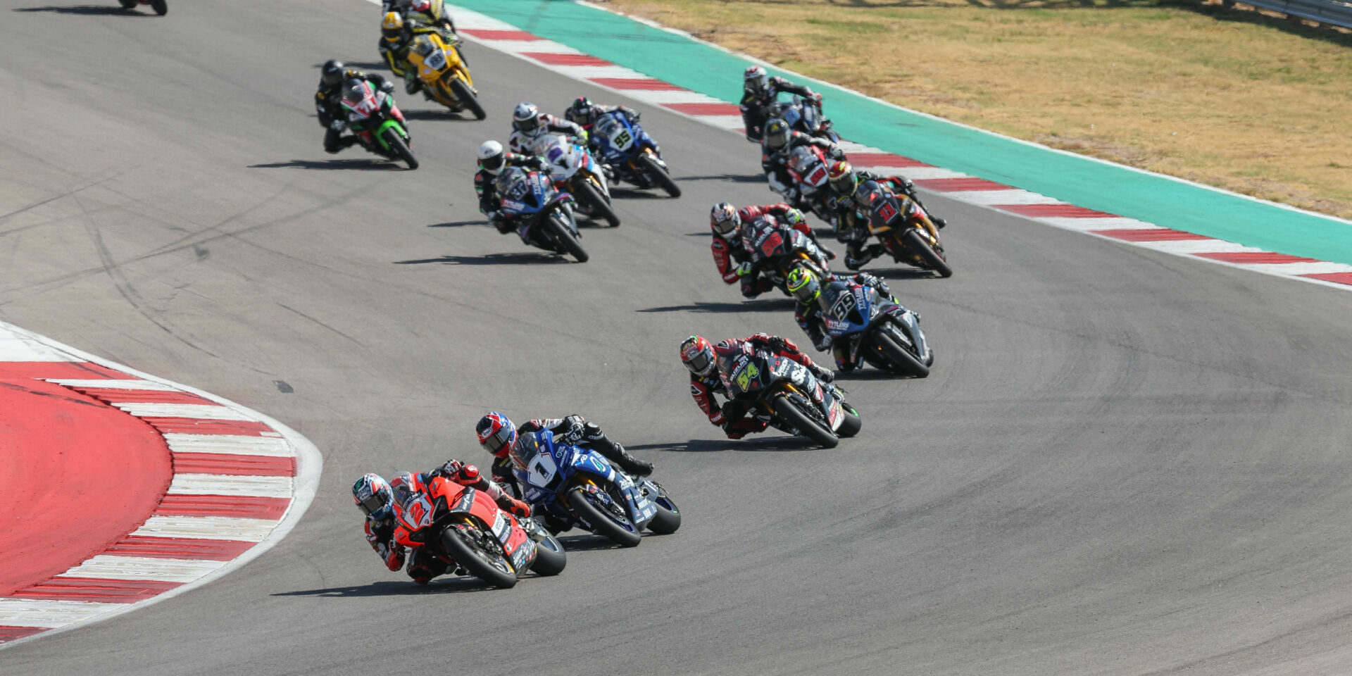 Josh Herrin (2) leads Jake Gagne (1), Richie Escalante (54), PJ Jacobsen (99), Brandon Paasch (96), Mathew Scholtz (11), and the rest of the field in MotoAmerica Superbike Race Two at Circuit of The Americas. Photo by Brian J. Nelson.