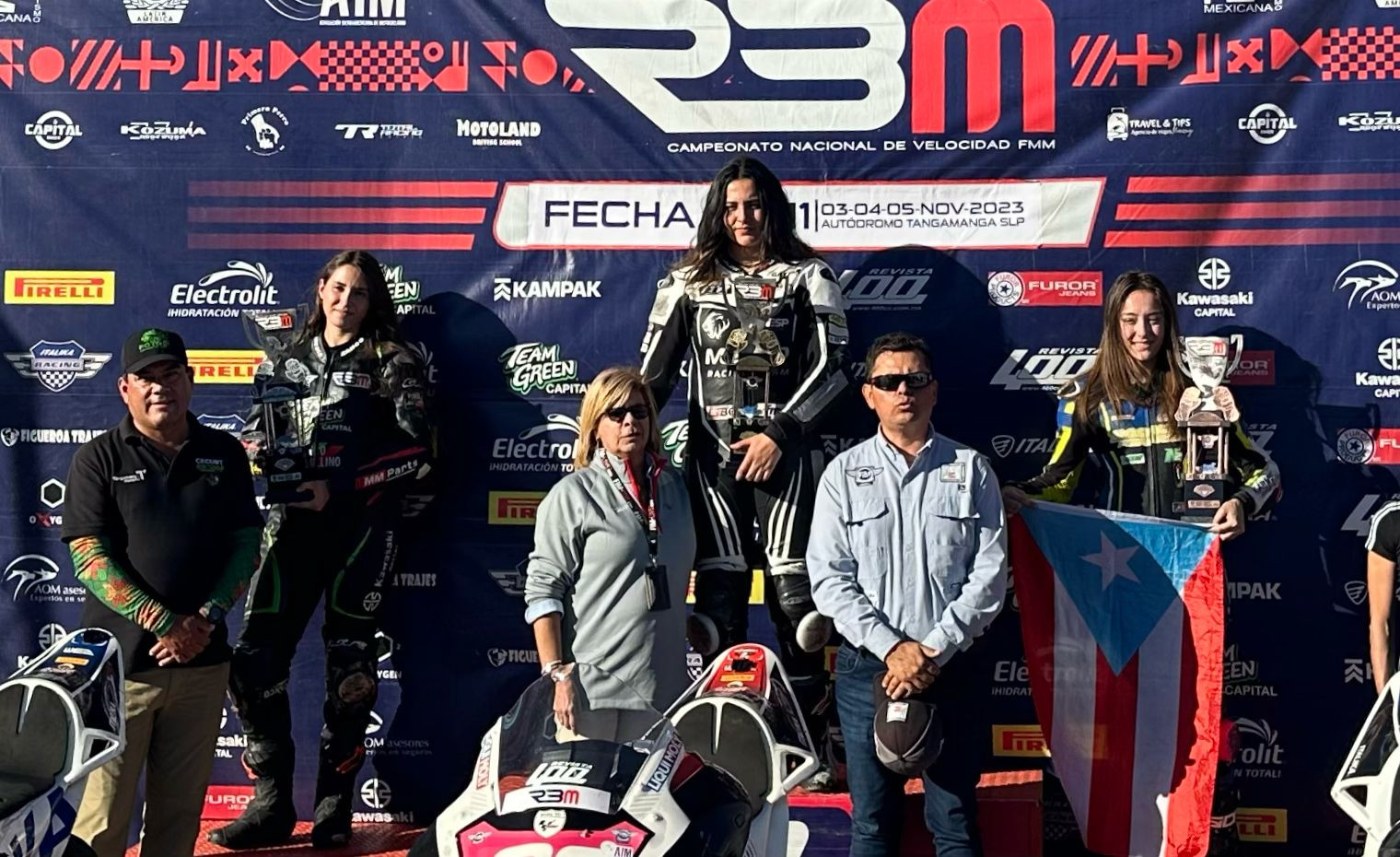 Race winner Astrid Madrigal (center), runner-up Nicole Zanco (left), and third-place finisher Elisa Gendron-Belen (right) FIM and RBM representatives on the podium in Mexico.   Photo by Aymme Belen.