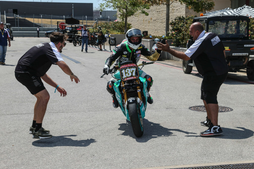 Stefano Mesa (137) is congratulated by members of the Tytlers Cycle Racing team on his way to the podium at Circuit of The Americas (COTA). Photo courtesy Energica.