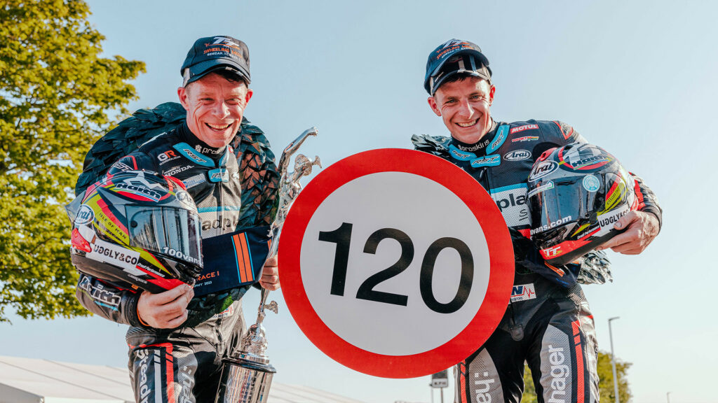 Tom Birchall (right) with older brother Ben Birchall (left) after doing a lap at over 120 mph average speed on their sidecar rig during the 2023 Isle of Man TT. Photo courtesy Isle of Man TT Press Office.