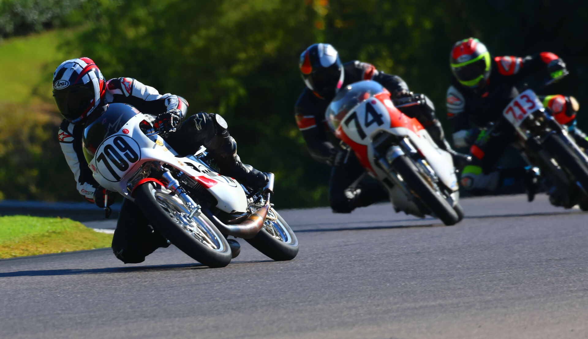 AHRMA racers Joe Ackley (709), Wes Orloff (74), and Maxon McLaughlin (713) at speed at Barber Motorsports Park. Photo by etechphoto.com, courtesy AHRMA.