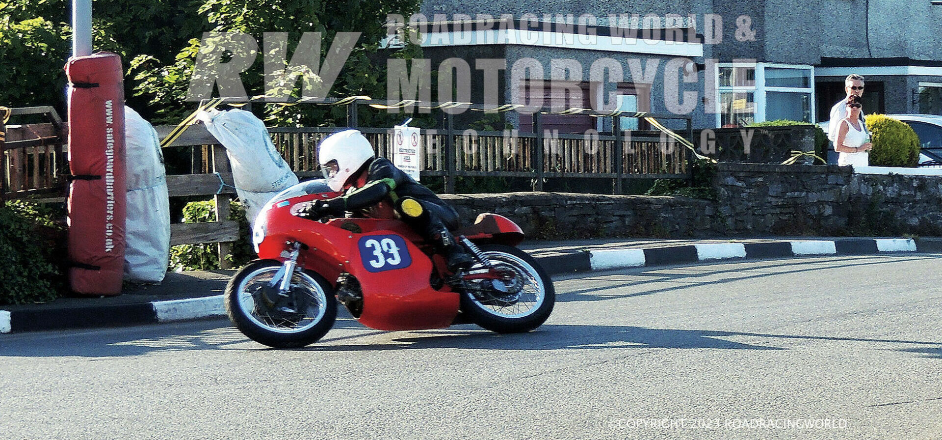 Typical real roads action shot, Brian Mateer at Castletown Corner on his 350cc Aermacchi. Spectators in their front garden are getting an up-close view, with haybales and foam padding on some of the immovable objects! Photos courtesy Mick Ofield.