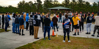 The rider's meeting at Precision Track Days' first-ever event, at Jennings GP in December 2023. Co-owner Fahad Khan (wearing a black vest near the corner worker shelter) is addressing the group. Photo courtesy Precision Track Days.