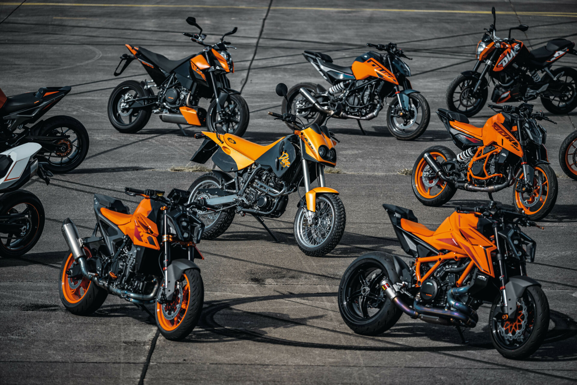 The original 1994 KTM Duke (center) with other KTM Duke models from throughout the years, including a 2024 KTM 990 Duke (bottom left) and a 2024 KTM 1390 Super Duke R EVO (bottom right). Photo by Rudi Schedl, courtesy KTM.