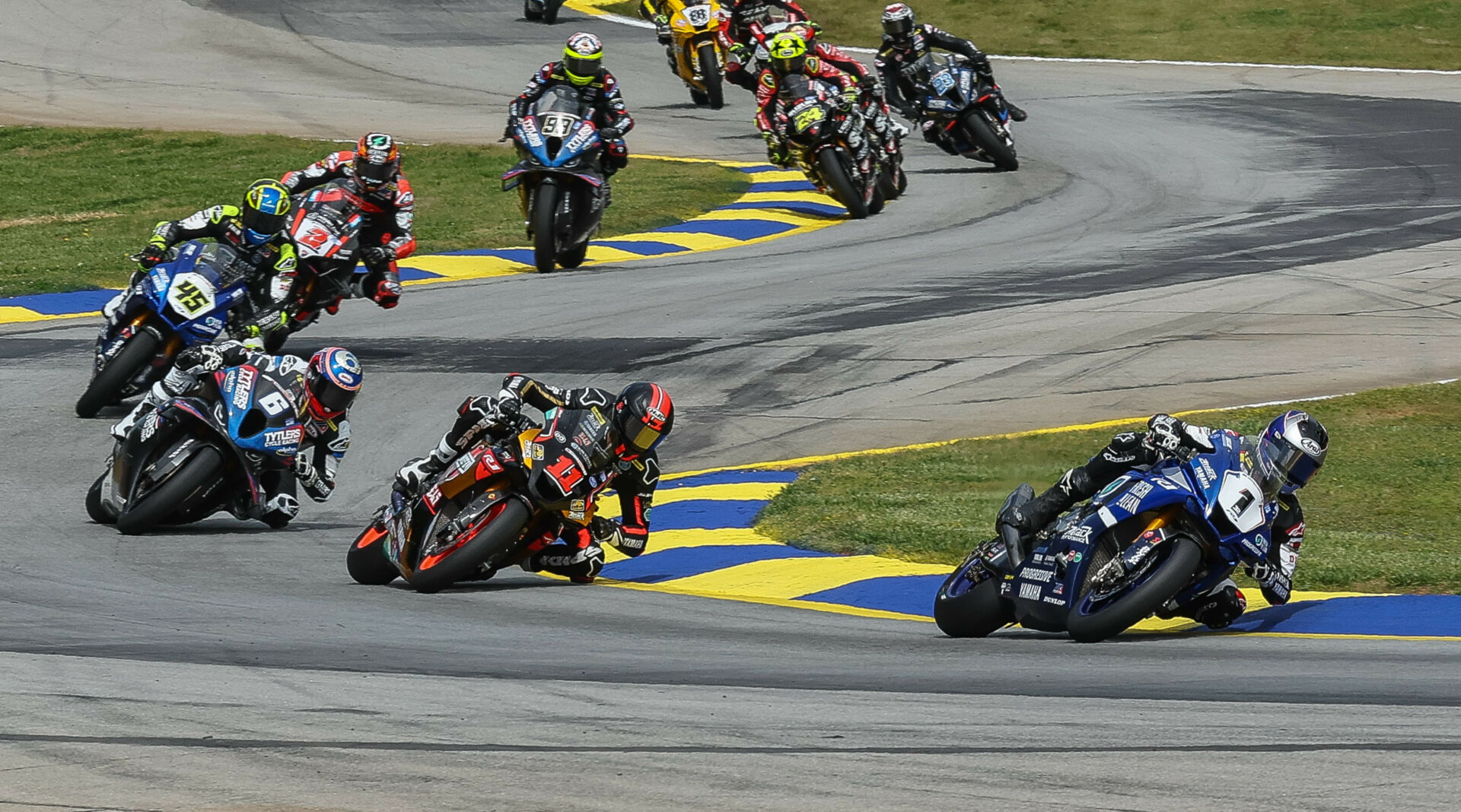 Jake Gagne (1) leading Mathew Scholtz (11), Cameron Beaubier (6), Cameron Petersen (45), Josh Herrin (2), PJ Jacobsen (99), Toni Elias (24), Richie Escalante (behind Elias), Corey Alexander (23), and the rest of the field during MotoAmerica Superbike Race One at Road Atlanta in 2023. Photo by Brian J. Nelson.