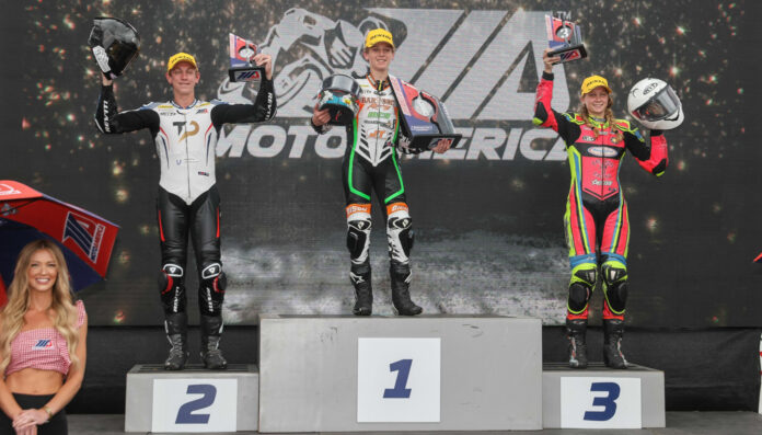 Avery Dreher, 17, (left) and Ella Dreher, 14, (right), when they made history by both finishing on the MotoAmerica Junior Cup podium at Brainerd. Matthew Chapin (center) won the rain-shortened race. Photo by Brian J. Nelson.