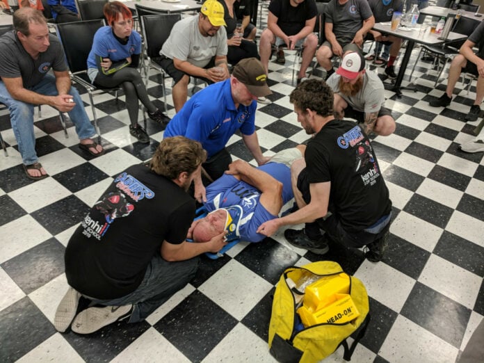 A mock crash patient has his head and neck stabilized with a brace in a first aid drill at a Carters@theTrack event. Photo courtesy Clive Savacool.
