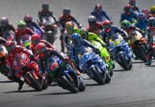 Riders charge into the first corner during a MotoGP race. Photo courtesy Dorna.